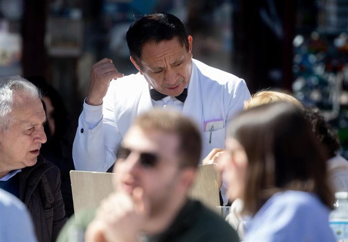 Archivo - Un camarero de nacionalidad extranjera atiende una mesa en una terraza en el centro de Madrid