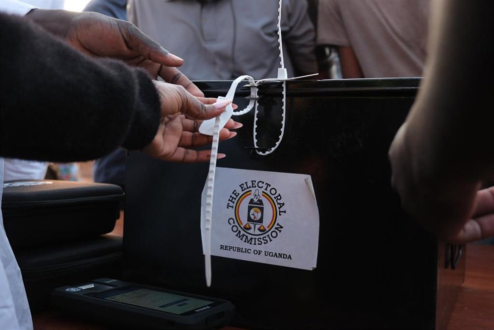 Un trabajador de la comisión electoral ante una urna durante las elecciones presidenciales y parlamentarias celebradas en Uganda el 15 de enero de 2026 (archivo)