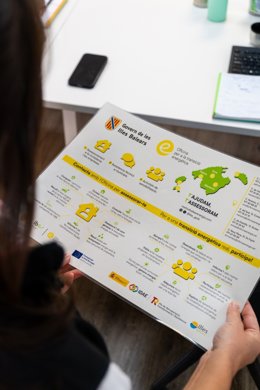 Una persona consulta un folleto de la Oficina para la Transición Energética de Baleares.