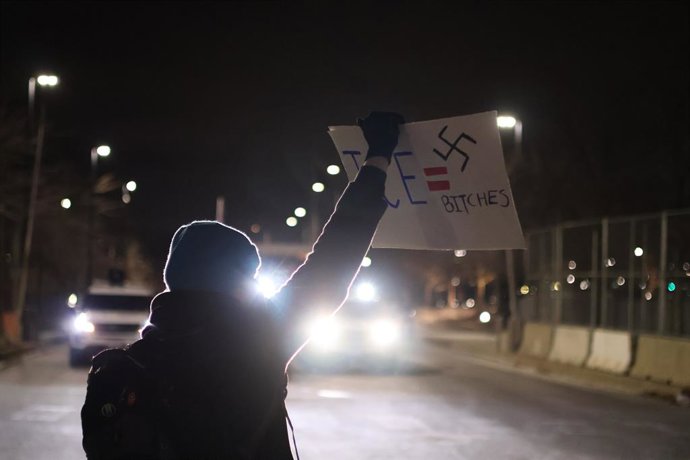 January 15, 2026, Minneapolis, Minnesota, USA: A protester holds up a sign to police outside the Whipple Federal Building in Minneapolis.