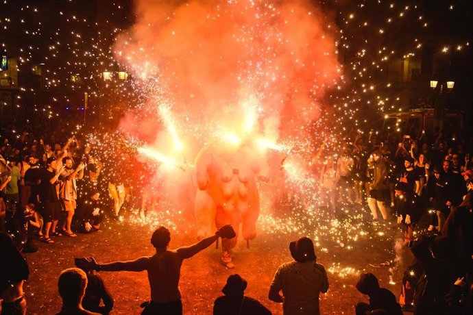 Archivo - 22 August 2022, Spain, Barcelona: People celebrate around a fire beast sets flying sparks during the Correfoc (fire-run) festival at the Festa Major de Gracia, the famous festival in Barcelona's Gracia neighbourhood. Photo: Matthias Oesterle/ZUM