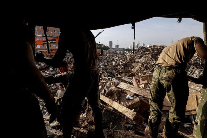 Archivo - Arxiu - Diverses persones caminen entre enderrocs a Sedaví després de la dana. ARXIU. 