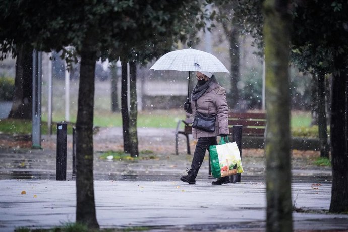 Archivo - Una mujer camina mientras nieva, a 27 de noviembre de 2021, en Vitoria, Euskadi (España). Catorce de las diecisieta comunidades autónomas tienen este sábado riesgo (aviso amarillo) o riesgo importante (aviso naranja) por nieve, lluvia, viento o 