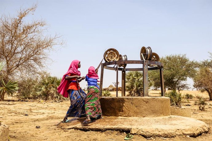 Archivo - Mahana, 9, and her sister Firdaoussou, 12, get water from a well.The well has only had water for 4 days and is polluted with frogs and garbage. When this well runs dry, they will need to go further.