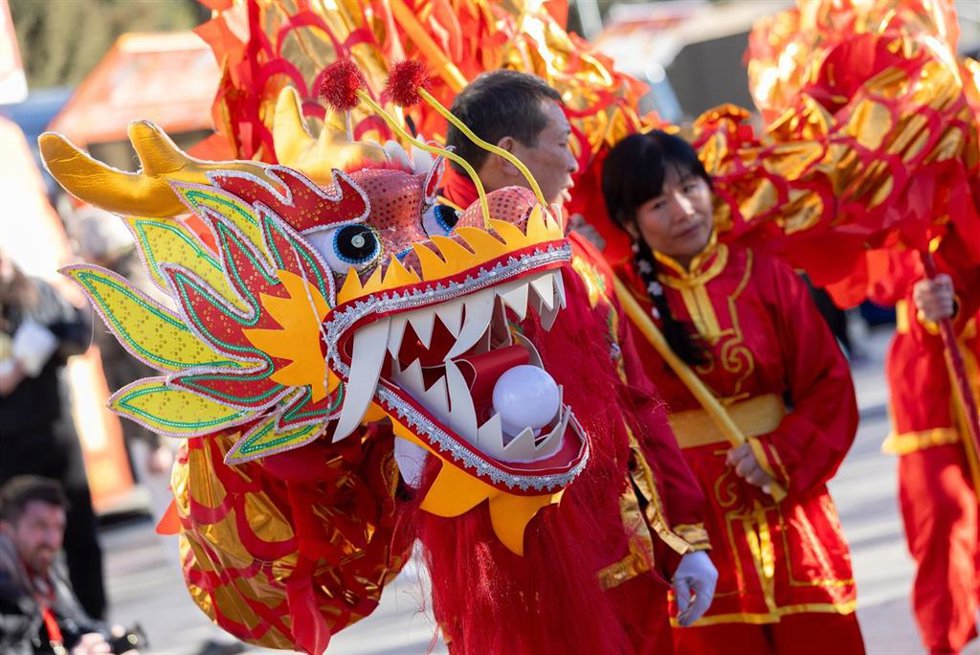 Archivo - Varias personas llevan un dragón en el mercadillo de artesanía china, en la explanada de la Junta Municipal Distrito de Usera