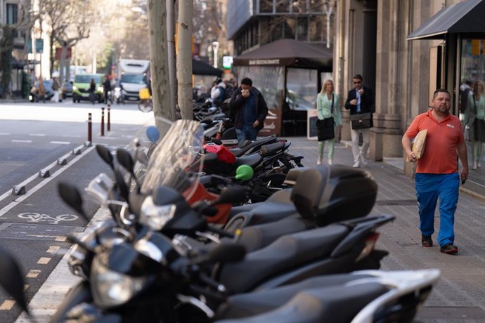 Archivo - Arxivo - Diverses persones caminen al costat de motos aparcades en la vorera, a 27 de març de 2025, a Barcelona, Catalunya (Espanya). La campanya, que s'estendrà durant els propers mesos, contempla la instal·lació de senyals de prohibició en els