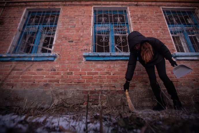 17 de janeiro de 2026, Sumy, Sumy, Ucrânia: Um vizinho recolhe vidros quebrados das janelas danificadas por um ataque com drones russos em Sumy.