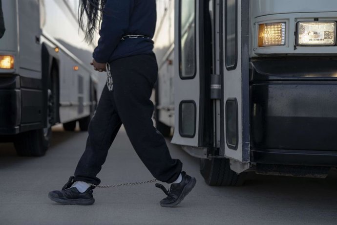 Archivo - Migrantes indocumentados esposados ​​descienden de un autobús mientras se preparan para abordar un avión de deportación de Estados Unidos a Guatemala desde Fort Bliss, El Paso, Texas