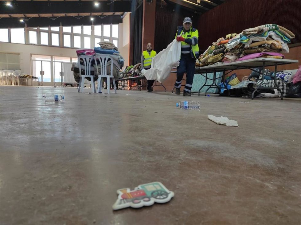 Operarios limpian y retiran enseres en la Caseta Municipal de Adamuz, donde se ha atendido a pasajeros y familiares afectados por el accidente ferroviario.
