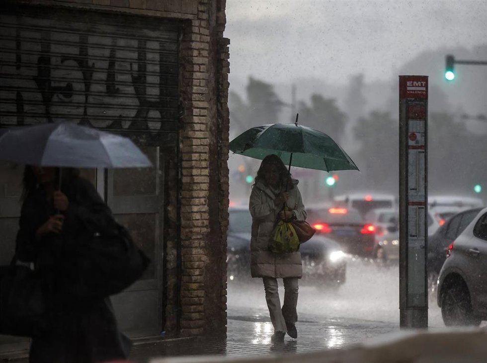 Archivo - Imagen de archivo de dos mujeres paseando por la calle bajo la lluvia