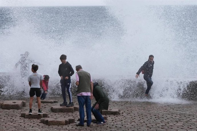Archivo - Varias personas se mojan con las olas en el Peine del Viento