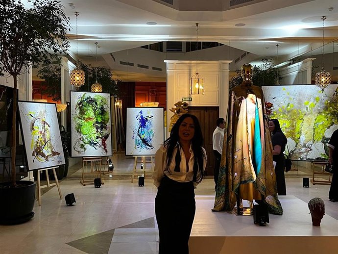 La artista Yubo Fernández entre algunas de sus obras expuestas en el Hotel Meliá Casa de las Artes, ubicado en Madrid.