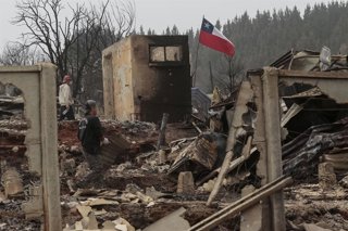 Residents netegen un àrea afectada per un incendi a Rossí, regió del Biobío, Xile