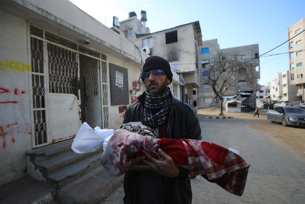 Un hombre palestino traslada el cadáver de la bebé Shaza abú Jarad, muerta a causa del frío invernal en la Franja de Gaza