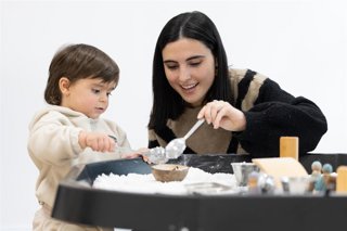 Una madre usuaria del programa CaixaProinfancia de la Fundación La Caixa cocinando con su hija.