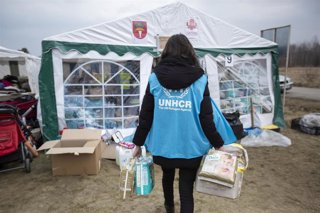 Archivo - UNHCR staff distributes food, hygiene materials and other items which were brought by volunteers at the Budomierz border crossing point