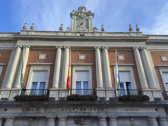 Fachada del Ayuntamiento de Huelva con las banderas a media asta.