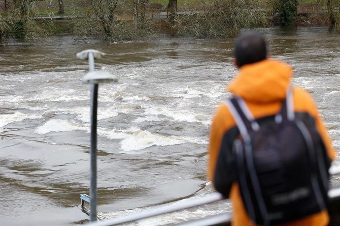 Archivo - Un hombre observa la crecida del río Miño, a 28 de enero de 2025, en Lugo