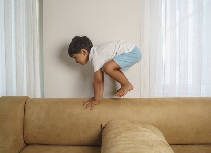 Archivo - Niño jugando en el sofá de su casa