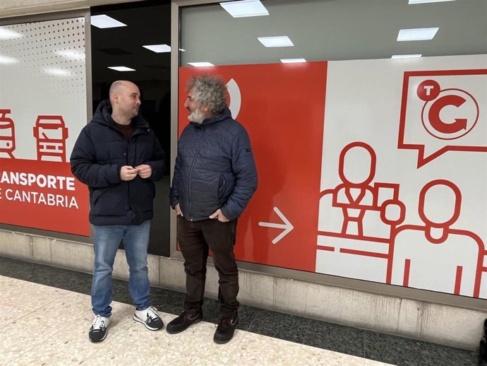 El coordinador de IU Cantabria, Israel Ruiz Salmón (izda), y Sergio Tamayo, integrante del partido, junto a la Oficina de Atención al Cliente Tarjeta TITC en la estación de autobuses de Santander