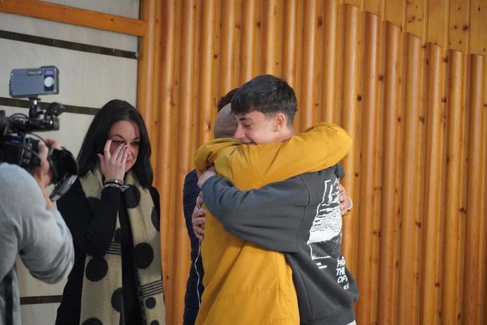 El joven de 16 años Julio Rodríguez se abraza con el padre de una de las víctimas del accidente de Adamuz a la que ayudó, originaria de Punta Umbría.