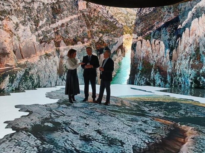 Manuel Blasco, Jorge Moncada y la directora general de Turismo de Aragón, María Jesús Gimeno, ante las pantallas del stand en Fitur.