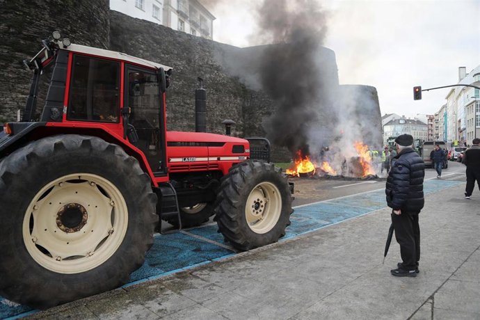 Hoguera de manifestantes de la tractorada que rodea la Muralla de Lugo desde el pasado lunes, frente a la Delegación de la Xunta de Galicia en Lugo, a 14 de enero de 2026, en Lugo, Galicia (España). Los ganaderos y agricultores gallegos continúan en pie d