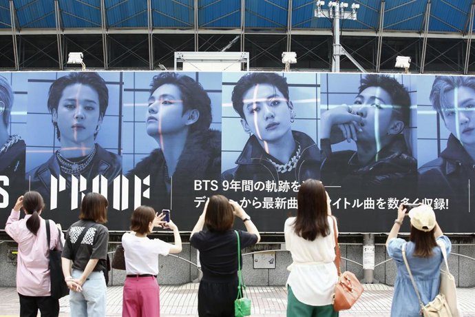 Archivo - June 10, 2022, Tokyo Japan: People take photos of a giant billboard of the South Korean boy band BTS (Bangtan Boys) announcing their new album Proof outside Shibuya Station. Their album Proof and its title track Yet To Come were released on June