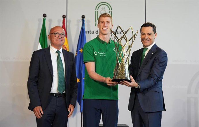 Archivo - El presidente de la Junta, Juanma Moreno, junto al capitán del Unicaja Baloncesto de Málaga, Alberto Díaz, y el presidente del Unicaja Baloncesto de Málaga, Antonio Jesús López Nieto, posan con el trofeo de la Basketball Champions League. 