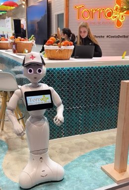 Unos robots humanoides reciben al visitante en el estand de Torrox en Fitur