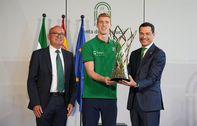 Archivo - El presidente de la Junta, Juanma Moreno (d), junto al capitán del Unicaja Baloncesto de Málaga, Alberto Díaz (c), y el presidente del  Unicaja Baloncesto de Málaga, Antonio Jesús López Nieto (i), posan con el trofeo de la Basketball Champions L