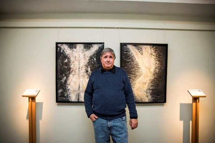 El pintor con discapacidad visual XavierE frente a dos de sus obras expuestas en el Museo Tiflológico de la Once.