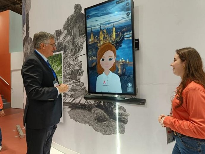 El consejero de Medio Ambiente y Turismo, Manuel Blasco, interactúa con la metahumana del stand de Aragón, una de las novedades de esta edición.
