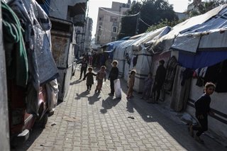 Palestinos desplazados por la ofensiva de Israel contra la Franja de Gaza junto a tiendas de campaña en las que viven ahora en la ciudad de Gaza (archivo)