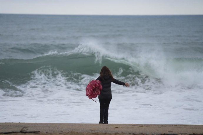 Una veïna de Barcelona sota la pluja a la Barceloneta