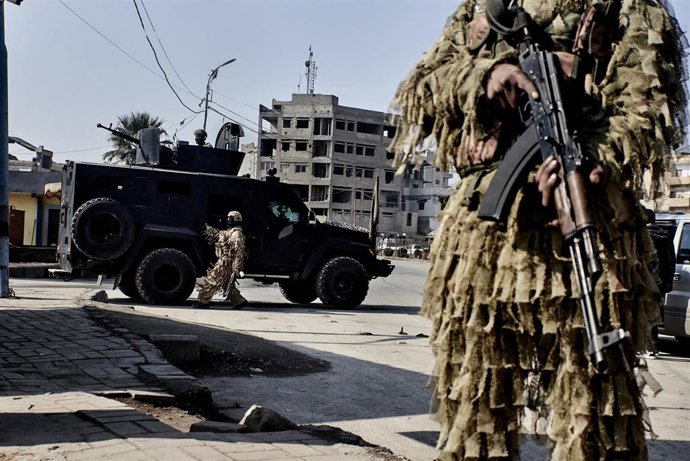 Archivo - Combatientes de las Fuerzas Democráticas Sirias, vigilan la plaza Al Naim durante una patrulla por las calles de la ciudad de Raqqa, en el este del país
