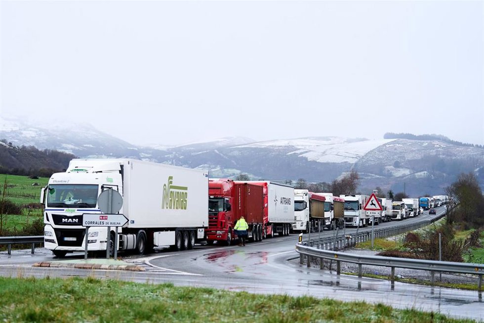 Archivo - Varios camiones parados en la A-67, a 18 de enero, en Cantabria (España) por la nieve