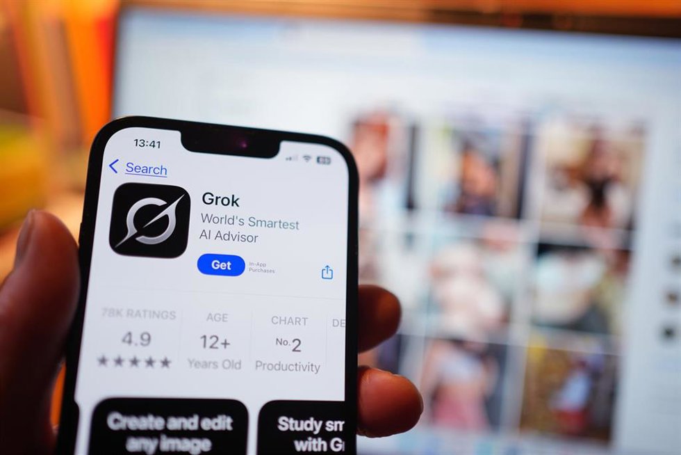 FILED - 08 January 2026, United Kingdom, London: Aview of the AI app Grok on the App Store on an iPhone, against a backdrop of search results displayed on the social media platform X (formerly Twitter) on a laptop. Photo: Yui Mok/PA Wire/dpa