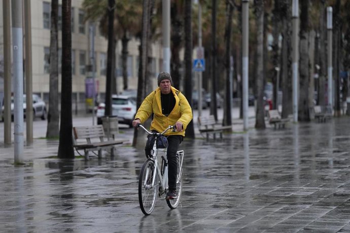 Hombre en bicicleta bajo la lluvia. Archivo.