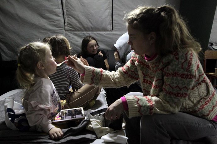 22 de janeiro de 2026, Kiev, Ucrânia: Uma menina alimenta uma criança em um ponto de aquecimento móvel no distrito de Desnianskyi, em Kiev, Ucrânia, em 22 de janeiro de 2026. O ponto de aquecimento foi instalado em meio a cortes de energia e aquecimento a