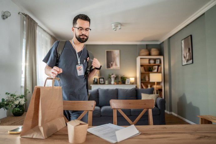 Archivo - Hombre trae a casa comida para llevar al volver del trabajo.