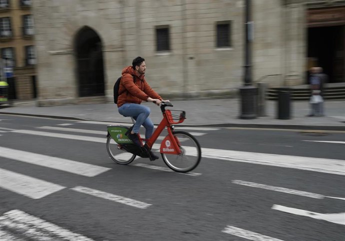 Archivo - Un hombre monta en bicicleta en Bilbao
