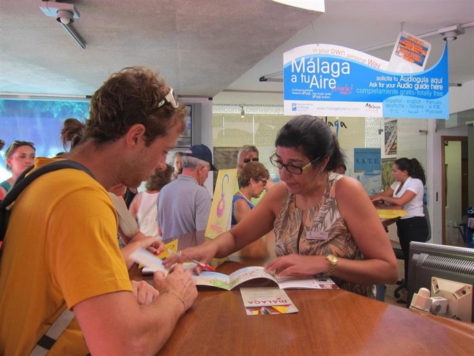 Archivo - Turistas informándose en una oficina de Málaga. Imagen de archivo.