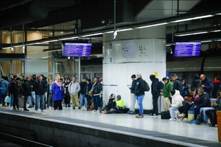 Viatgers a l'andana de l'Estació de Sants (Barcelona) a primera hora d'aquest dilluns