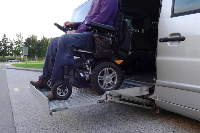 Una persona dependiente en silla de ruedas, en un vehículo adaptado.