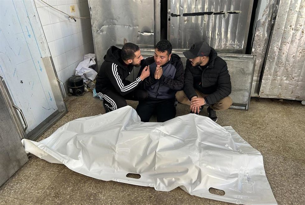 Palestinos junto al cadáver de un hombre muerto por disparos del Ejército de Israel en el campamento de refugiados de Al Bureij, en el centro de la Franja de Gaza, pese al alto el fuego en vigor desde el 10 de octubre de 2025 (archivo)