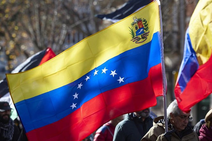 Manifestantes portan bandera de Venezuela durante una marcha antiimperialista, a 25 de enero de 2026, en Madrid (España). La marcha, que recorre las calles de Madrid desde el Ministerio de Exteriores hasta la embajada de EEUU, tiene por objetivo expresar 