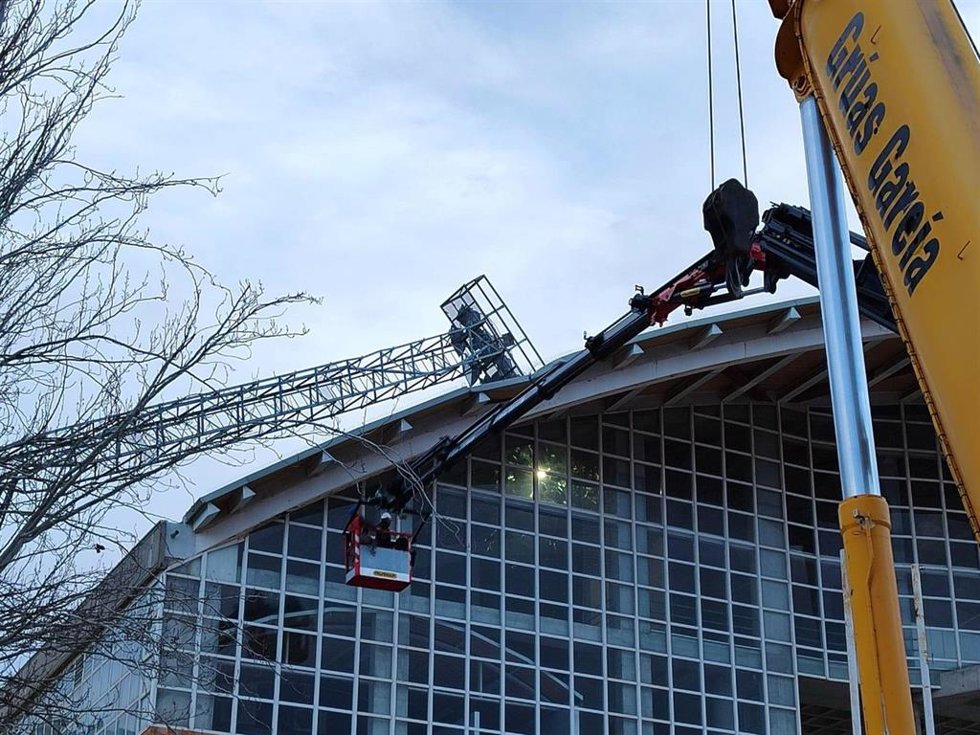 Operarios desmontan una torre eléctrica que cayó sobre un pabellón por las fuertes rachas de viento en Villena