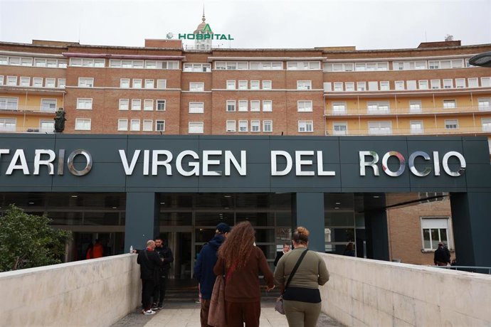 Dos personas se dirigen al acceso principal del Hospital Virgen del Rocío.