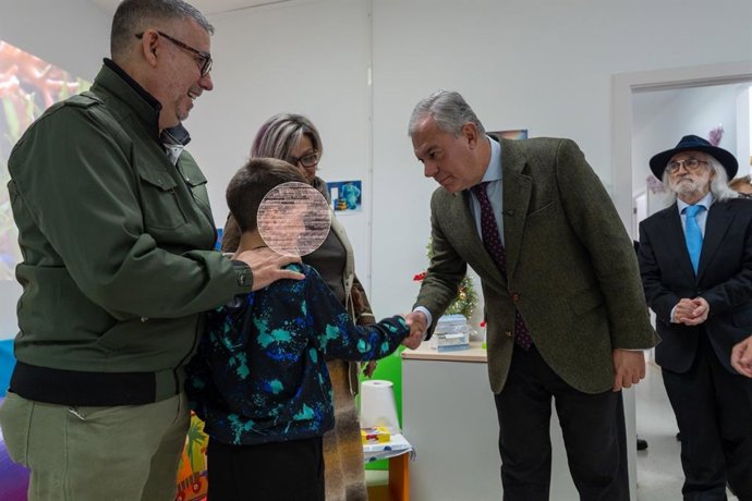 El alcalde de Sevilla saluda a un menor inmerso en el programa de ayudas del Consistorio para reforzar la acción social de las entidades.